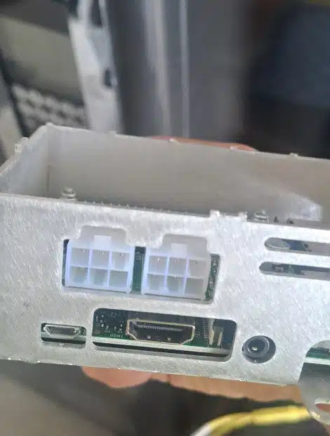 A close-up of an electronic device's metal casing shows an 8-pin and 6-pin power connector, an HDMI port, and a USB-C port on a circuit board.